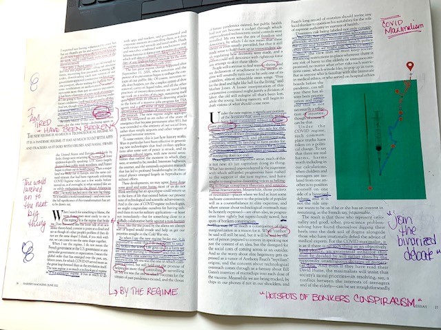 Picture of an open magazine, with the text heavily marked up (including underlines, circles, and notes) in purple and pink ink.